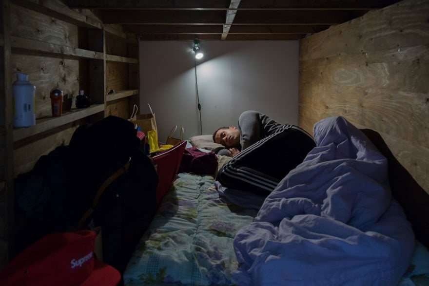 homem dormindo em espaço pequeno