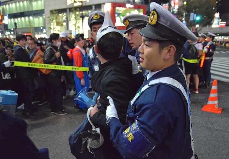 Policialprende pessoa em Shibuya no Halloween